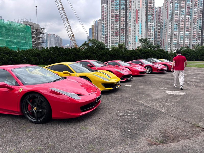 一列法拉利跑車停泊在空地上，背景為香港住宅樓宇