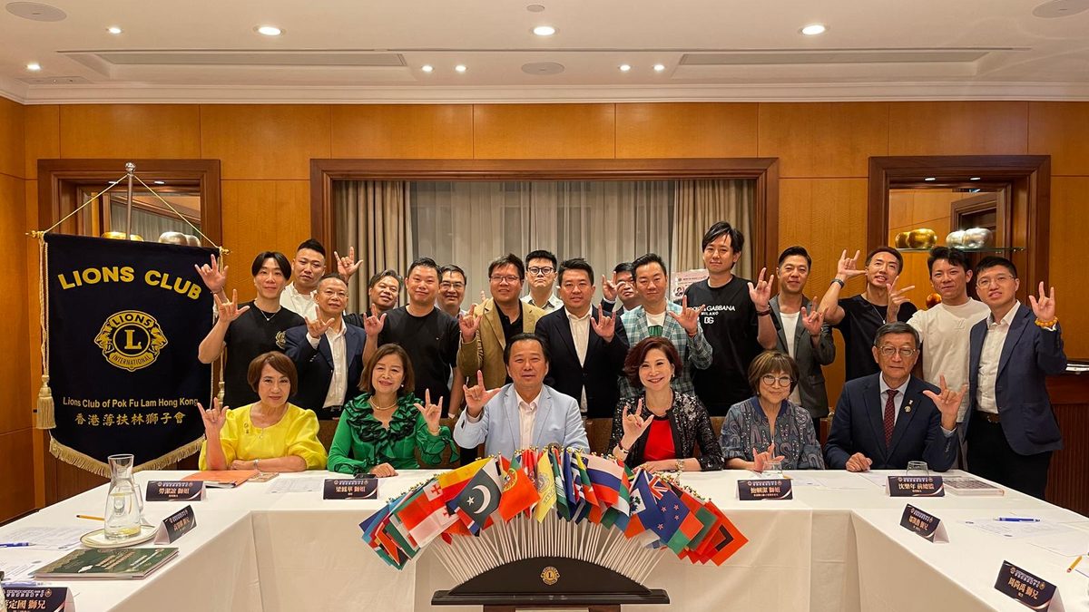 獅友於香港賽馬會舊會所合照,前方懸掛香港薄扶林獅子會會旗